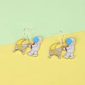 Detailed view of astronaut earrings with yellow moon in shopping cart charms