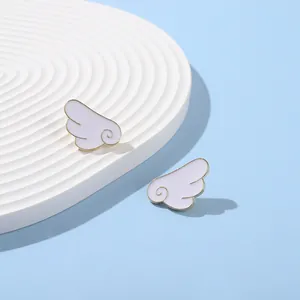 Detail of angel wing enamel badges with purple paint and gold metallic edges