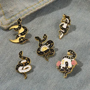 5-piece mystical serpent enamel pin set with crescent moon and skull on denim fabric