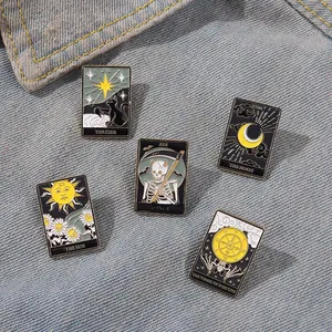 Detail von Emaille-Pins im Tarot-Design mit Sonne Mond und Sternen auf Denim-Stoff