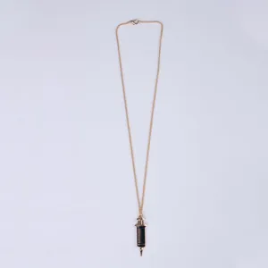 Detailed view of the medical syringe pendant with golden chain and black scale markings