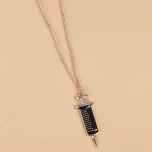 Macro detail of medical syringe pendant featuring black enamel and gold scale marks