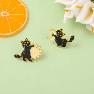 Detailed view of alloy enamel pins featuring black cats holding sun and moon motifs
