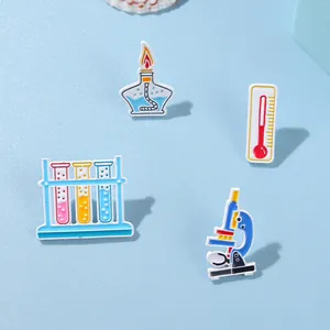 Laboratory science enamel pin set featuring microscope and test tubes on blue background