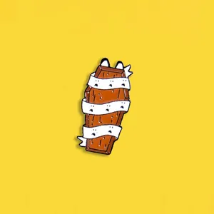 Detail of cartoon mummy coffin enamel pin with white bandages on yellow background