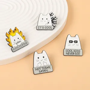 Détail de quatre épingles en émail de chat blanc amusantes avec slogans sur socles