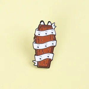 Detail of Halloween enamel pin featuring a wood grain coffin wrapped in ghost ribbons