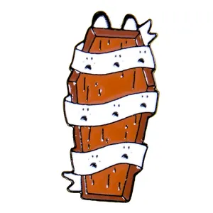 Detailed view of enamel coffin pin with cat ears and white bandage patterns