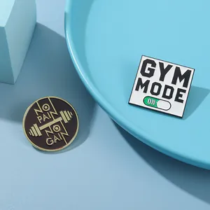 Close-up of Gym Mode and No Pain No Gain enamel pins with workout motivation slogans