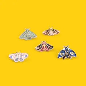 Vue détaillée de cinq broches papillon en émail coloré aux motifs célestes