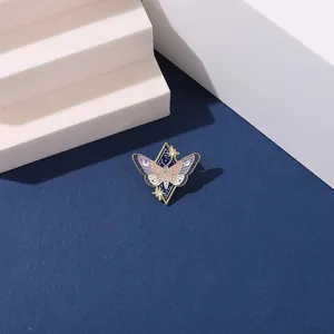 Close-up of alloy insect butterfly brooch with starry geometric details on dark blue fabric