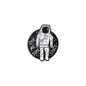 Detalle del broche de astronauta esmaltado con texto Give Me Some Space y fondo estrellado