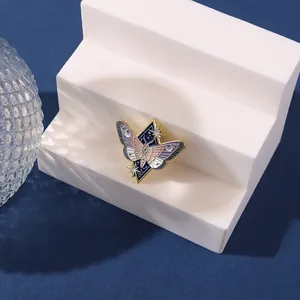 Detailed close-up of a butterfly enamel pin with crescent moon and star patterns