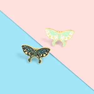 Artistic moth enamel pins with moon phases in dark and light green with gold edges