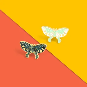 Artistic insect enamel pins featuring crescent moon and star patterns on vivid backgrounds