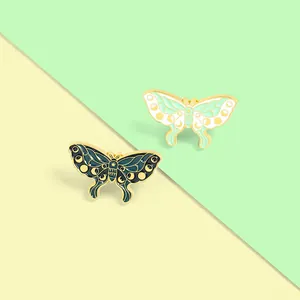 Detail view of colorful butterfly enamel pins with intricate patterns and golden metallic finish