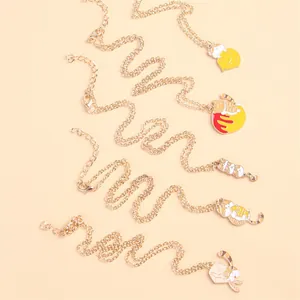 Detail of five cute cartoon cat pendants with colorful enamel on fine gold-tone chains