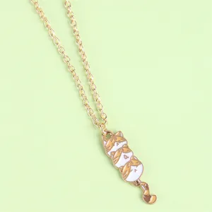 Close-up of golden necklace featuring a cute triple-stacked cartoon cat pendant with enamel finish