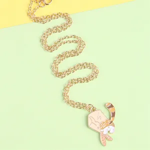 Detailed macro view of a cute cartoon cat pendant on a gold chain with vibrant enamel finish