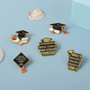 Close-up of enamel graduation lapel pins with floral and doctoral cap designs