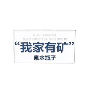 Detail view of rectangular enamel pin with white base and blue humorous text engraving