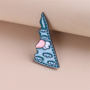 Detail van de creatieve emaille speld met blauwe bergen en roze hartpatronen