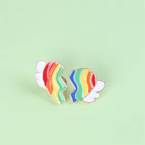 Emaille broches in de vorm van een regenbooghart met witte vleugels en gouden afwerking