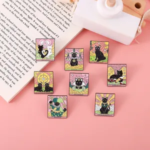 Detailed close-up of colorful black cat tarot enamel pins on a vintage open book
