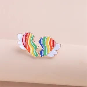 Detailopname van de asymmetrische regenboog hart oorbellen met vergulde rand en wolken