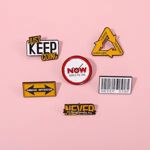 Detailed view of six enamel pins with Keep motivational phrases on a pink background