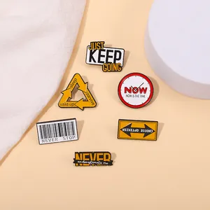 Close-up of alloy enamel pins with Keep Going and Never Stop motivational quotes
