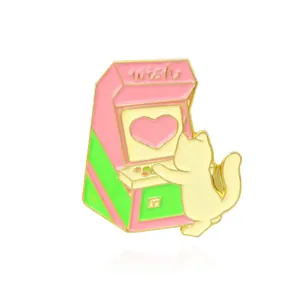 Close-up of a cartoon cat playing a retro arcade machine enamel pin with wish text