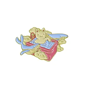 Detail of enamel cat brooch featuring a pink bowl, blue whale, and white clouds
