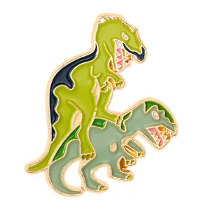 Detail view of the enamel dinosaur brooch showing polished green finish and gold metal edges