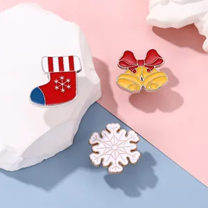 Three-piece Christmas brooch set featuring a holiday sock, golden bells, and white snowflake