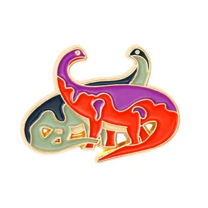 Macro shot of abstract colorful dinosaur enamel pin with polished gold metal edges