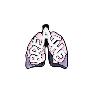 Detail of pink lung-shaped enamel brooch with Breathe text and metal alloy outlines