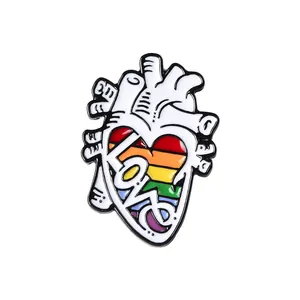 Detailed view of white heart enamel pin featuring colorful rainbow LOVE lettering