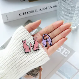Cute pink and purple cat enamel pins held by hand, minimalist animal brooch accessories