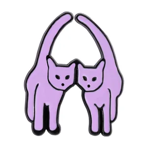 Close-up of two purple enamel cat pins forming a heart shape with their tails