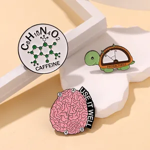 Three creative enamel pins featuring chemical formulas, a turtle protractor, and a pink brain