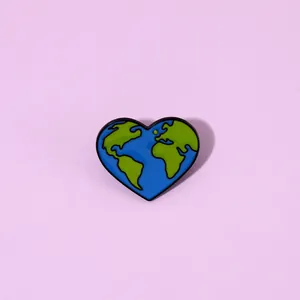 Macro view showing the detailed heart shaped earth enamel pin with blue and green colors