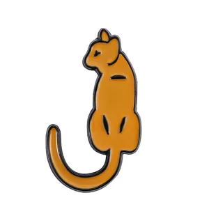 Detailed close-up of a cute orange enamel cat pin with black metal outlines for bags
