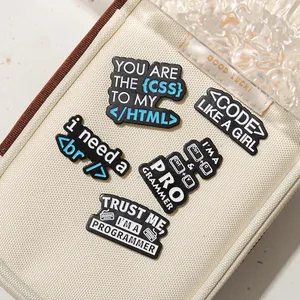Detailed close-up of five programmer-themed enamel pins on an off-white canvas bag