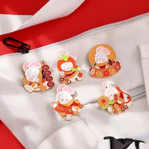 Détail de 5 broches lapin en émail avec vœux festifs sur un sac en toile blanc