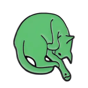 Macro detail of cute green cat enamel brooch pin with black metallic outlines on white background