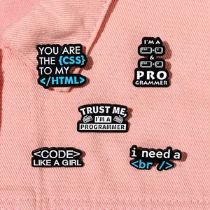 Detail of programmer-themed enamel pins with coding tags on pink denim fabric