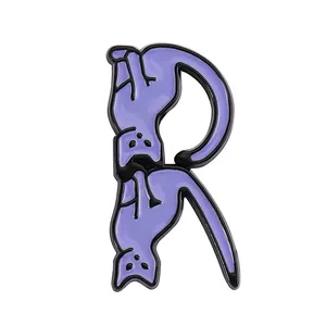 Macro shot of cartoon purple cat enamel pin in the shape of alphabet letter R