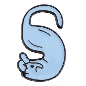 Close-up of light blue enamel letter S brooch with creative cartoon cat animal silhouette