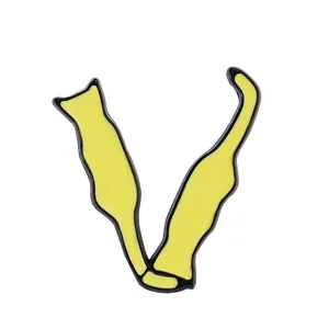 Detail view of yellow enamel cat alphabet brooch with black metal outline and V-shape silhouette
